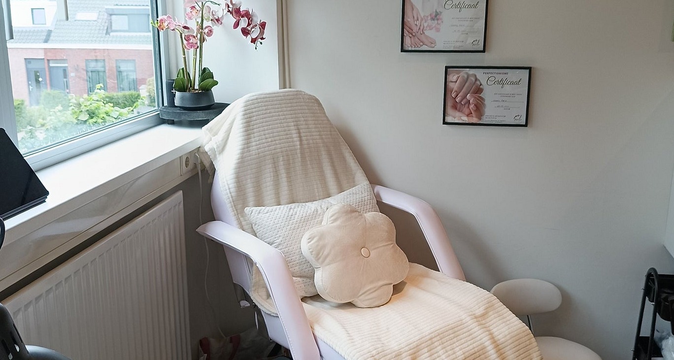 De pedicurestoel bij het raam, met een orchidee op de vensterbank