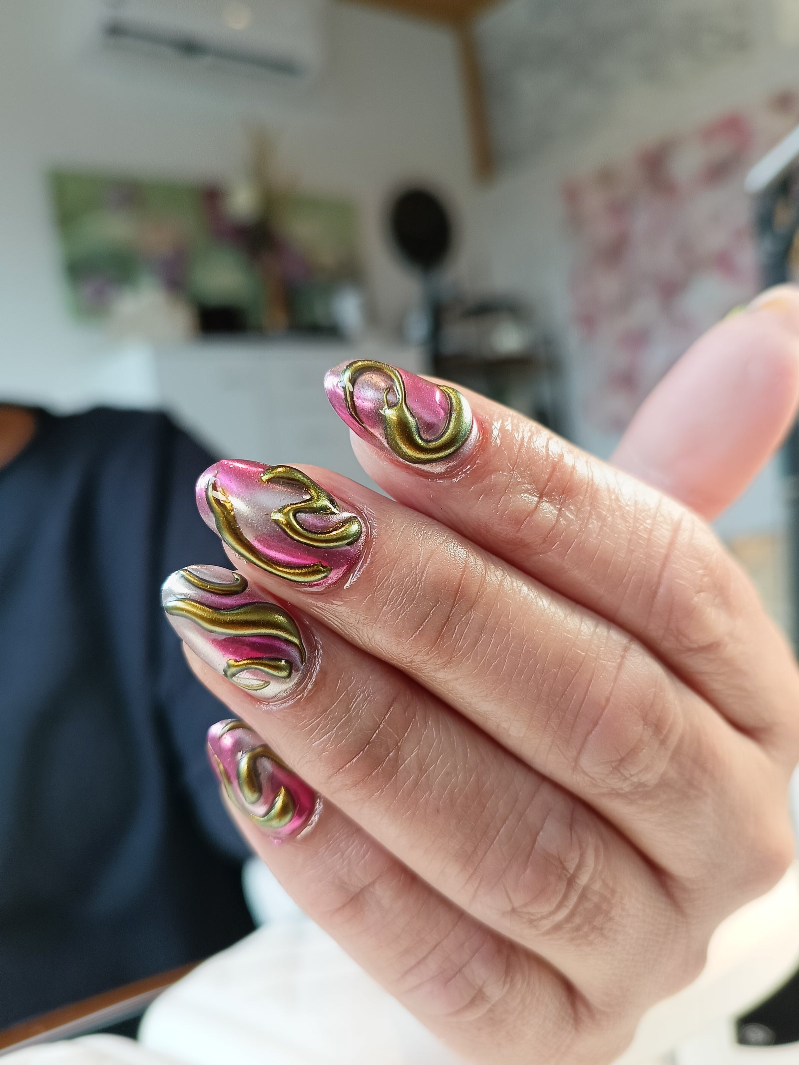 Nail art met chrome swirls in roze en goud