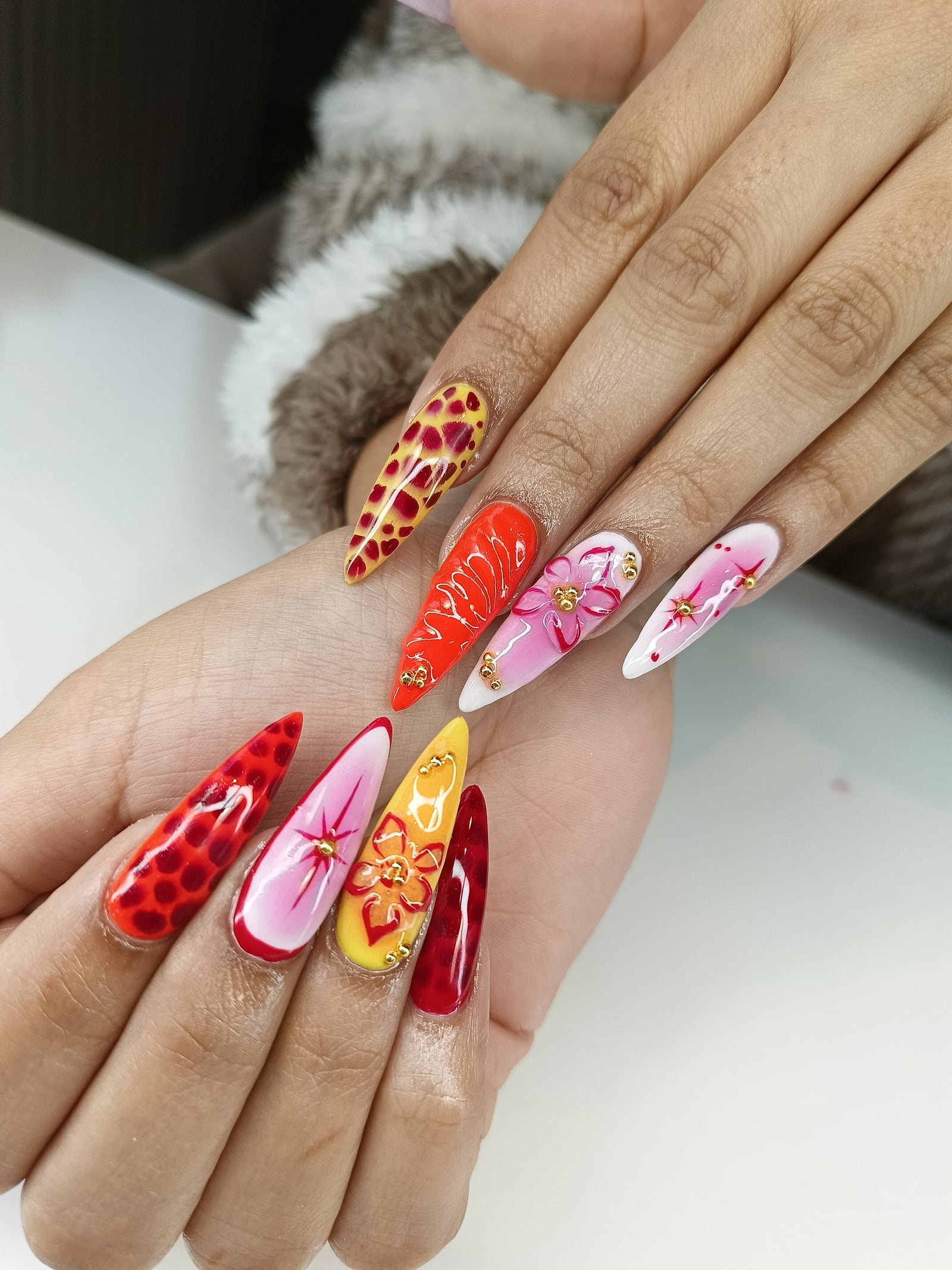 Lange stiletto nagels met bloemen in rood, roze en oranje